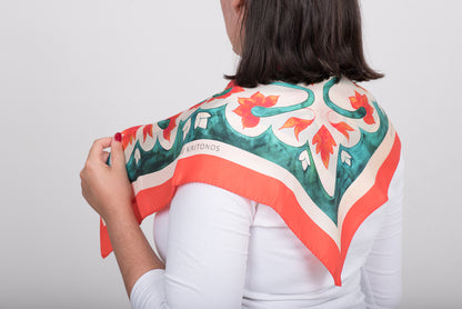 Teal Attica Garden silk scarf draped on the back of model