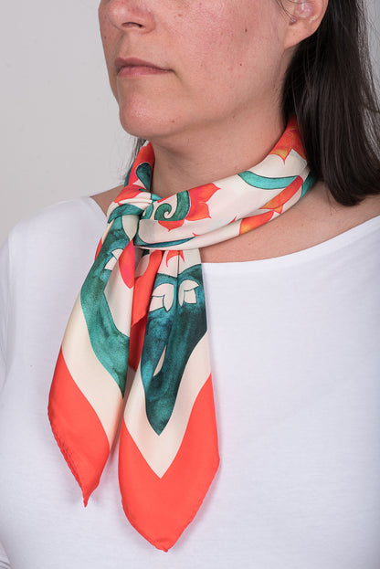 Teal Attica Garden silk scarf tied around neck over plain white t-shirt