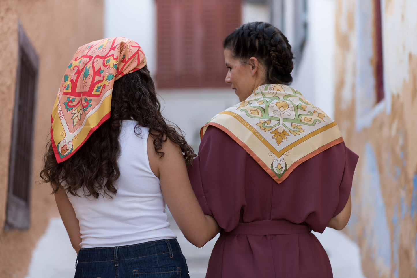 Two models styling red and cream Mesogeia Blooms silk scarves on head and back