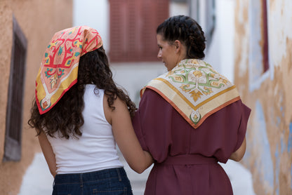 Two models styling red and cream Mesogeia Blooms silk scarves on head and back