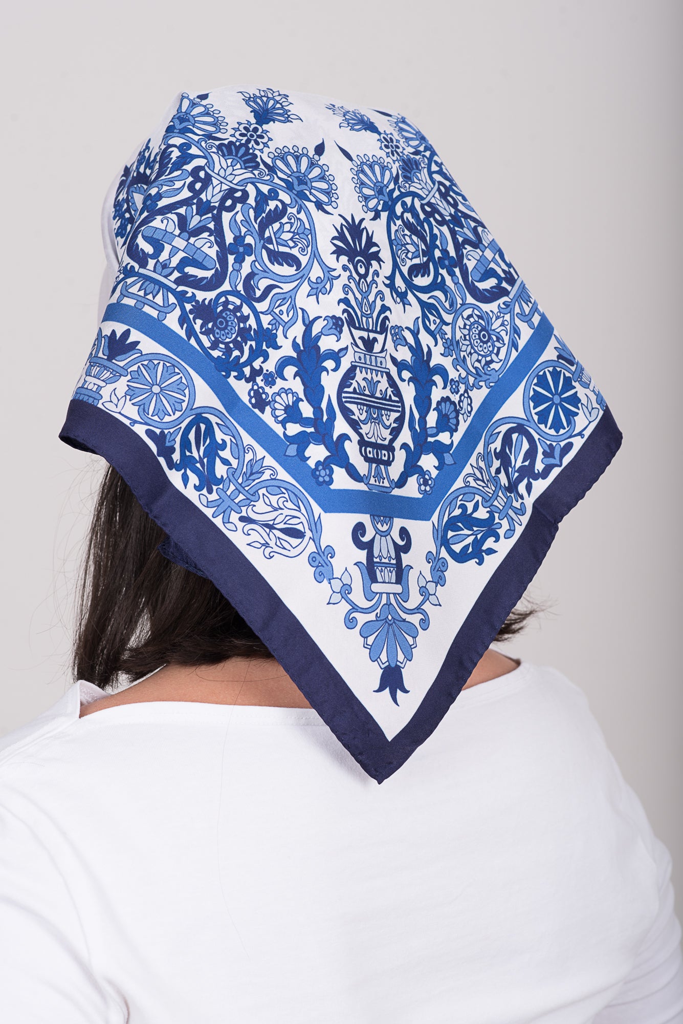 Greek folk art inspired square silk scarf in blue tones worn as head wrap