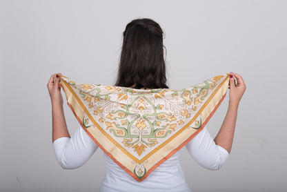 Hand-drawn floral silk scarf in cream called Mesogeia Blooms by Ariadne Kritonos held on model's back to show the design