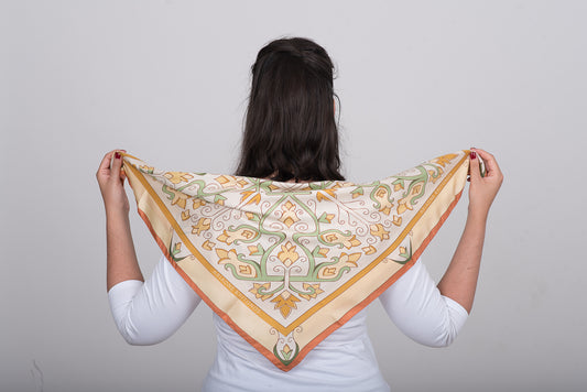 Hand-drawn floral silk scarf in cream called Mesogeia Blooms by Ariadne Kritonos held on model's back to show the design