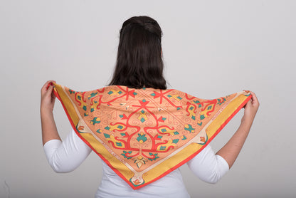 Floral orange, pink and red silk scarf tied at the back in simple styling pose to showcase the design