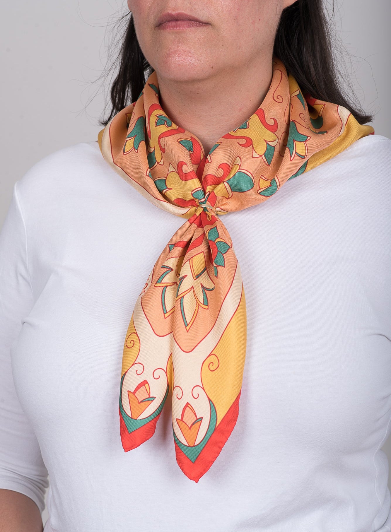 Orange and Red Mesogeia Blooms silk scarf tied simply on neck with scarf ring over plain top