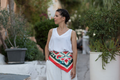 Woman styling the teal Attica Garden silk scarf on her waist, with pink Attica Garden scarf shown at end on second woman