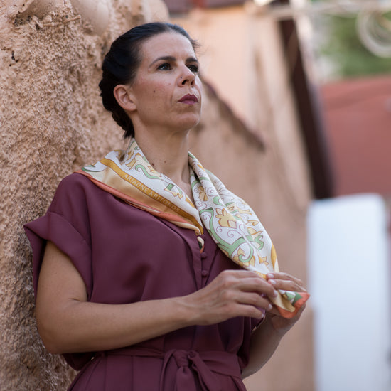 Video of model admiring her cream Mesogeia Blooms floral silk scarf, ending with red Mesogeia Blooms scarf worn by second model as headscarf.