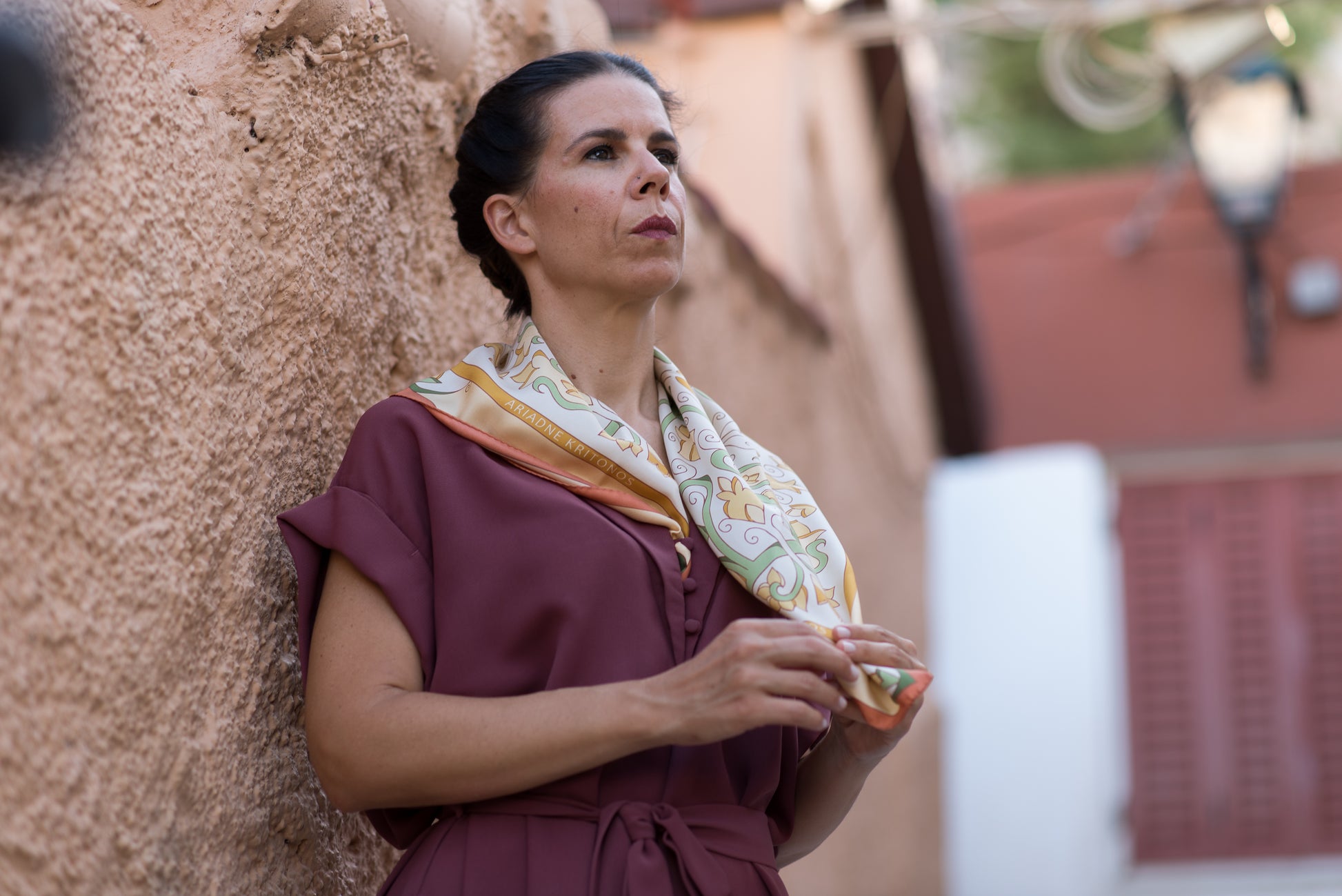 Video of model admiring her cream Mesogeia Blooms floral silk scarf, ending with red Mesogeia Blooms scarf worn by second model as headscarf.